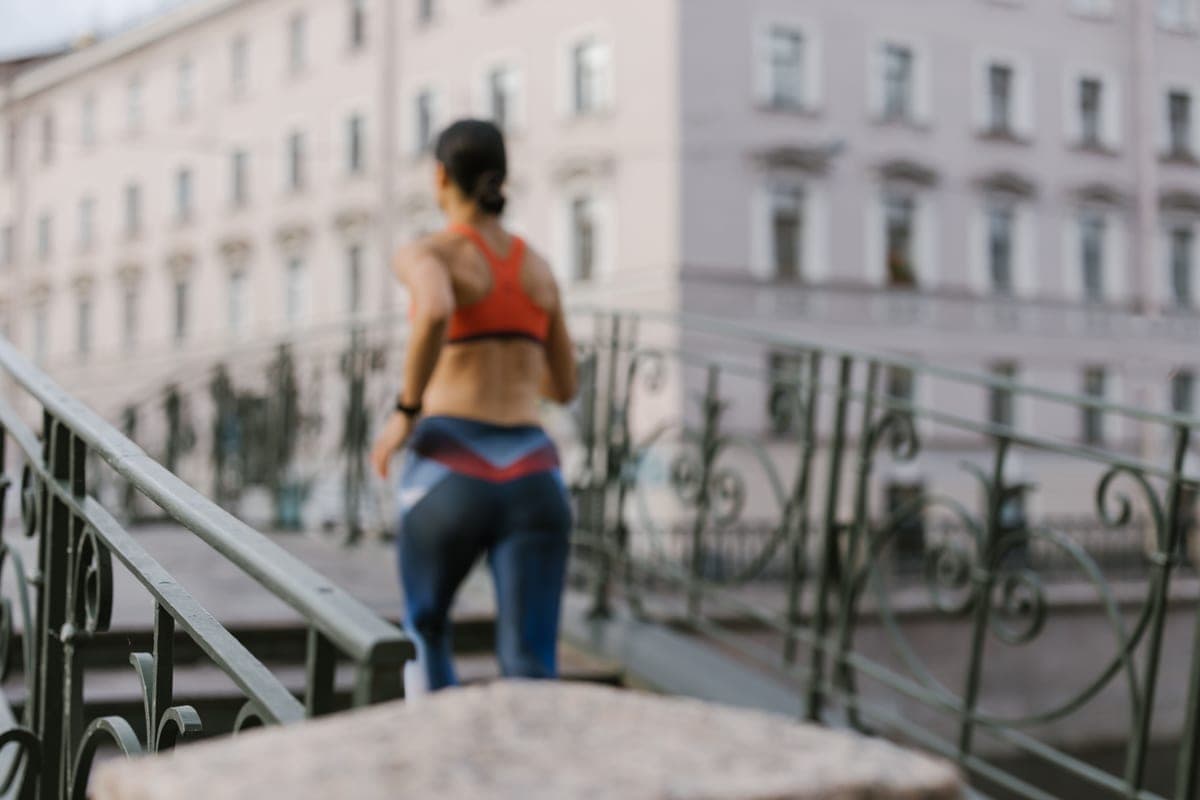 A runner jogging across a city bridge