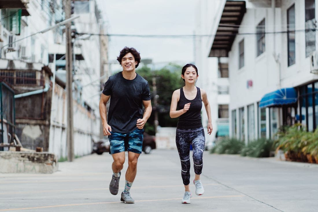Two people jogging together on a neighborhood street